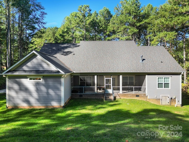 back of house with a yard and a sunroom