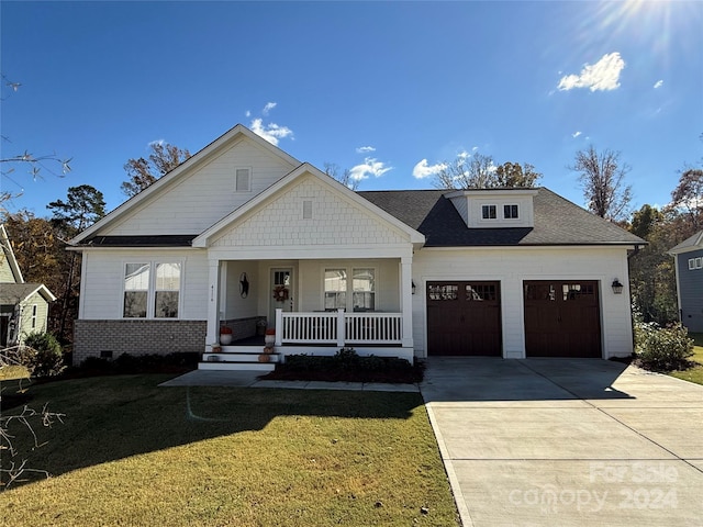 view of front facade with a porch, a garage, and a front lawn