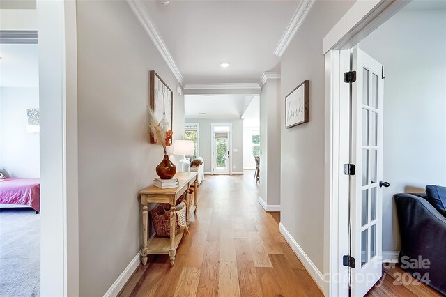 hall with light hardwood / wood-style flooring and ornamental molding