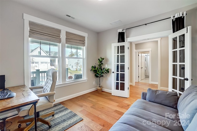 office with french doors and hardwood / wood-style flooring