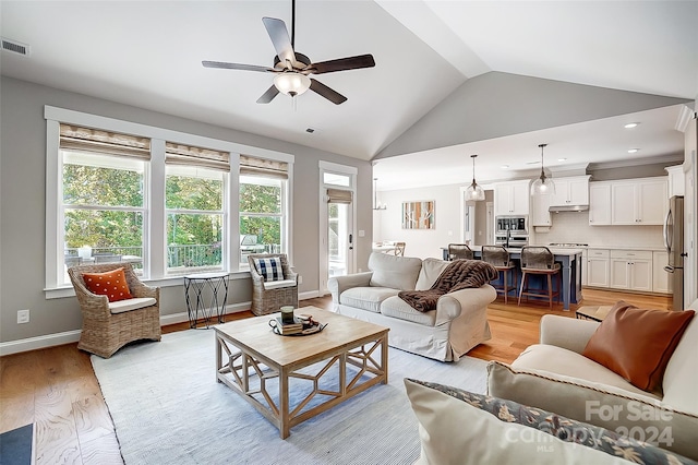 living room with ceiling fan, light wood-type flooring, and lofted ceiling