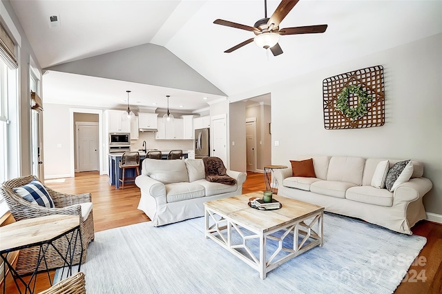 living room with ceiling fan, light hardwood / wood-style flooring, and high vaulted ceiling