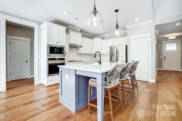 kitchen with white cabinetry, an island with sink, light wood-type flooring, and appliances with stainless steel finishes