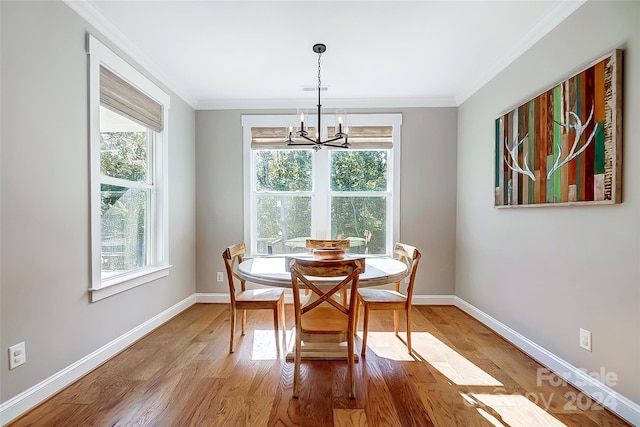 dining area featuring hardwood / wood-style flooring, a notable chandelier, and ornamental molding