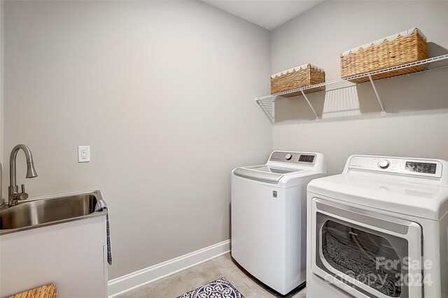 clothes washing area featuring washing machine and dryer and sink