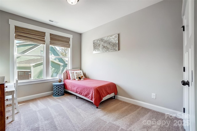 carpeted bedroom featuring baseboards and visible vents