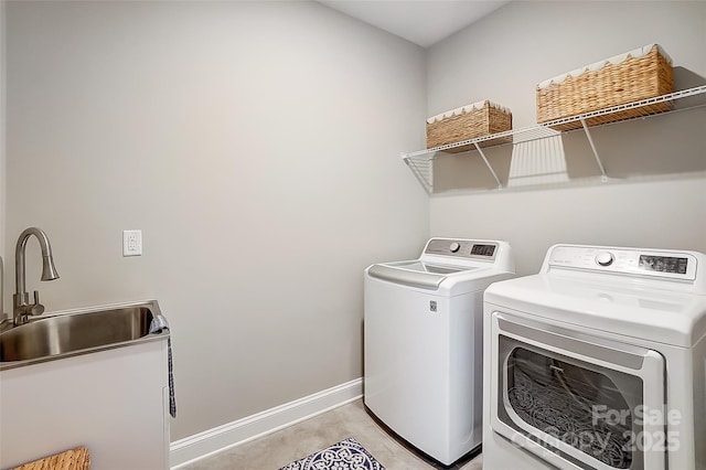 laundry area featuring laundry area, washer and clothes dryer, baseboards, and a sink