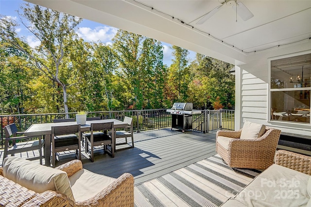 wooden deck featuring outdoor dining area, grilling area, and a ceiling fan