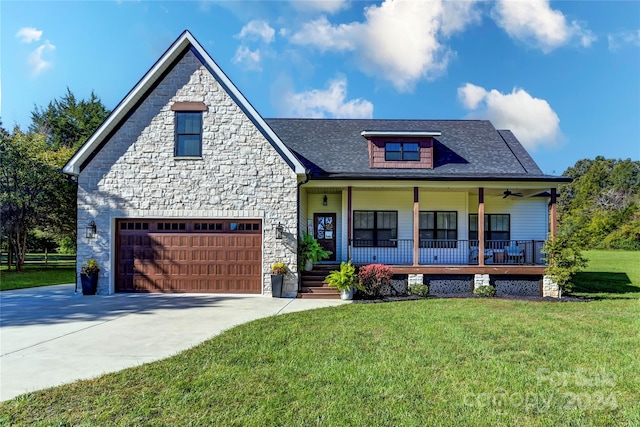 view of front of property featuring a front yard, a porch, and a garage