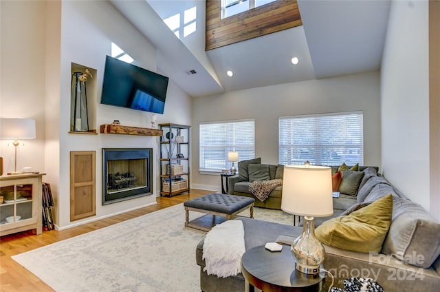 living room with hardwood / wood-style floors, high vaulted ceiling, and plenty of natural light