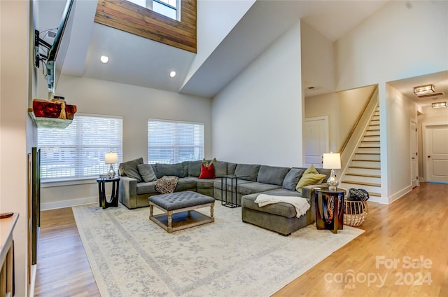 living room featuring a healthy amount of sunlight, high vaulted ceiling, and wood-type flooring