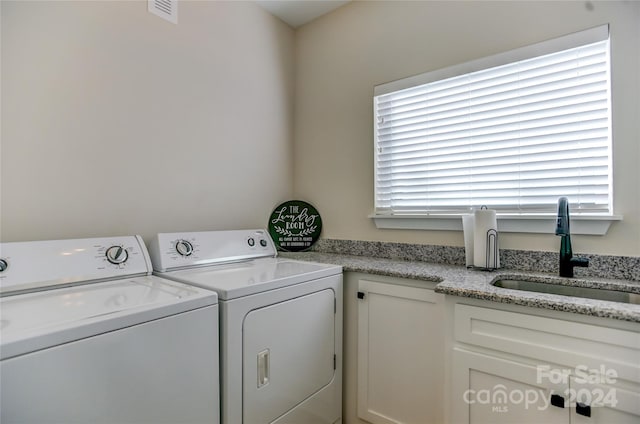 laundry room with cabinets, plenty of natural light, sink, and washer and clothes dryer