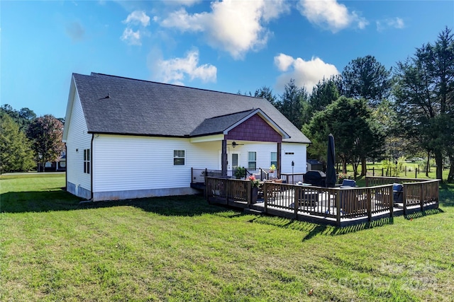 rear view of house with a deck and a lawn