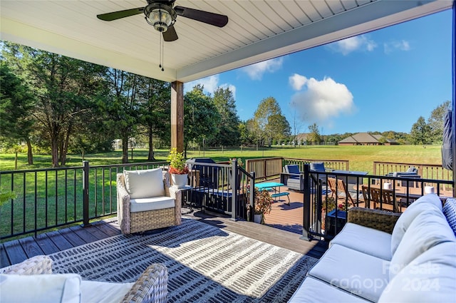 wooden terrace with ceiling fan, a lawn, and an outdoor living space