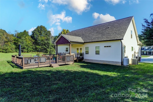 back of property featuring a deck, a lawn, and cooling unit