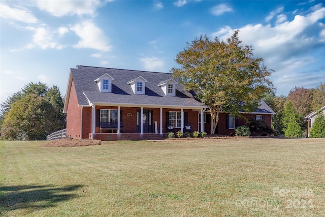 new england style home featuring a front yard and a porch