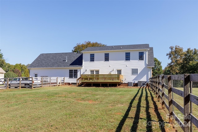 rear view of house with a deck and a lawn