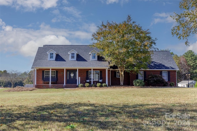 new england style home with a front yard and covered porch