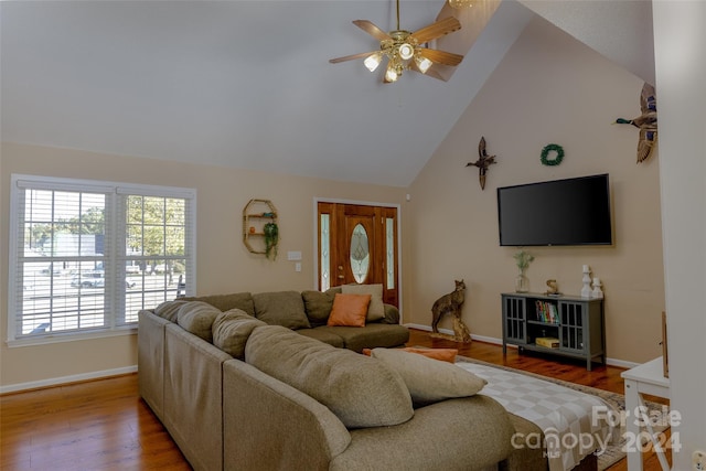 living room with light hardwood / wood-style flooring, high vaulted ceiling, and ceiling fan