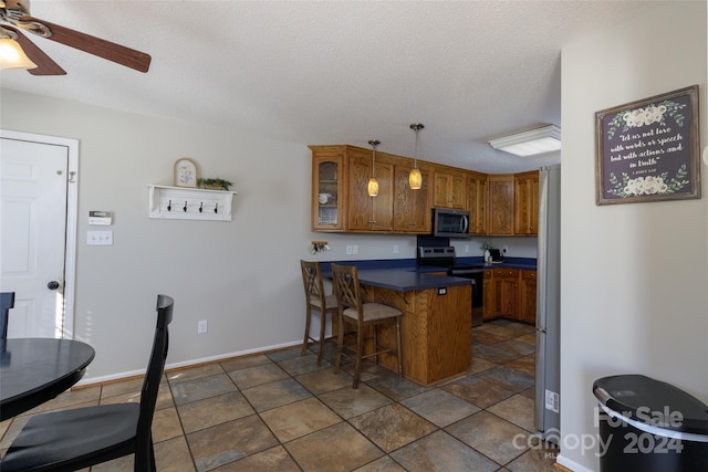 kitchen featuring a kitchen breakfast bar, hanging light fixtures, kitchen peninsula, appliances with stainless steel finishes, and ceiling fan