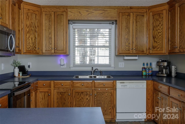 kitchen featuring white dishwasher, black range with electric stovetop, sink, and a textured ceiling