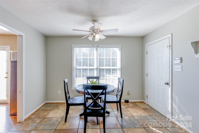 dining space with ceiling fan and a textured ceiling