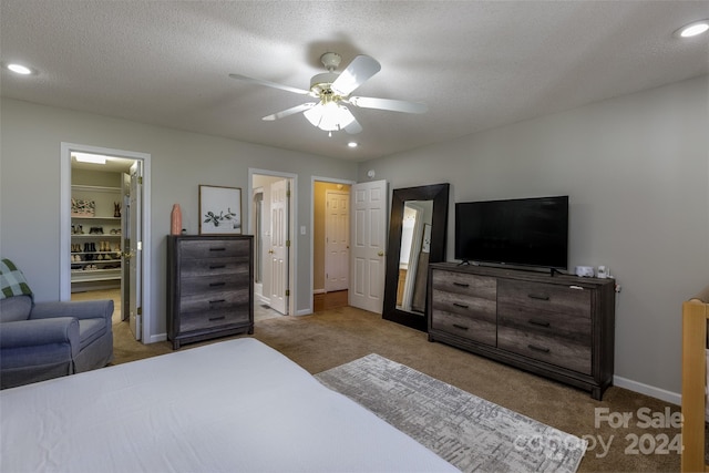 bedroom featuring light carpet, a textured ceiling, and ceiling fan