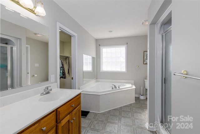 full bathroom with vanity, shower with separate bathtub, and toilet