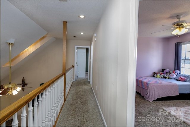 hall featuring a textured ceiling and carpet