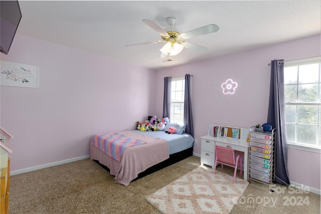 carpeted bedroom with multiple windows, a textured ceiling, and ceiling fan