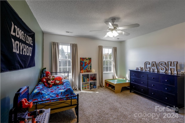 bedroom with multiple windows, a textured ceiling, carpet flooring, and ceiling fan