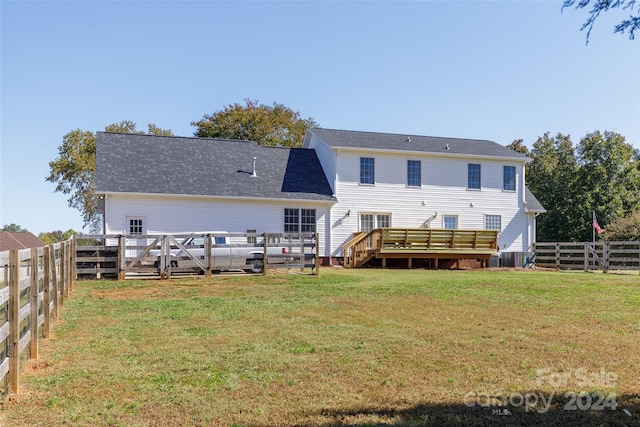 back of house featuring a wooden deck and a lawn