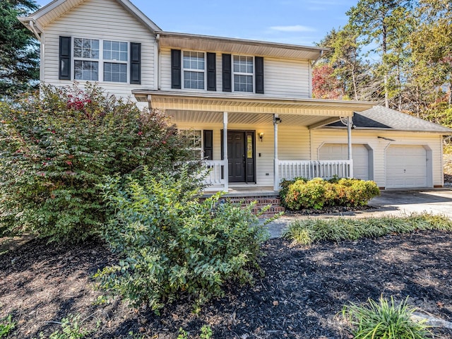 view of property with a garage and a porch