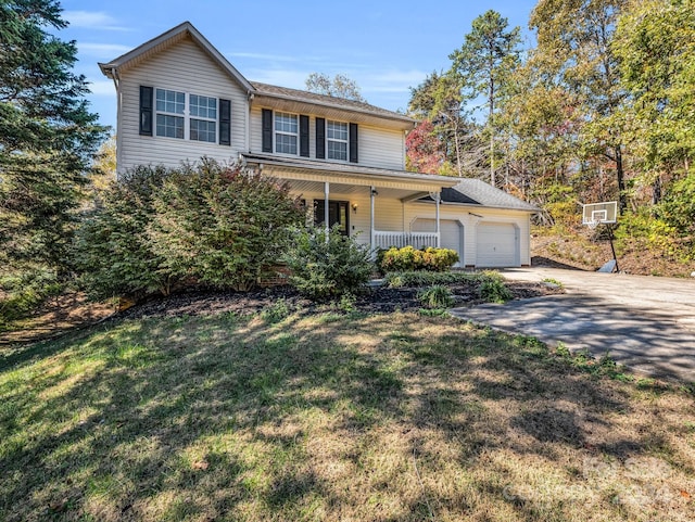 view of front of house with a front lawn, covered porch, and a garage