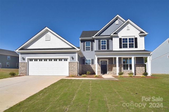 craftsman-style house with a front yard, a garage, and covered porch