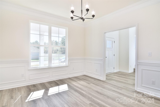 unfurnished dining area with a chandelier, ornamental molding, a wealth of natural light, and light wood-type flooring