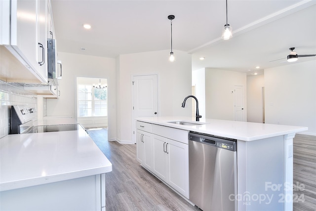 kitchen featuring hanging light fixtures, white cabinetry, a kitchen island with sink, sink, and stainless steel appliances