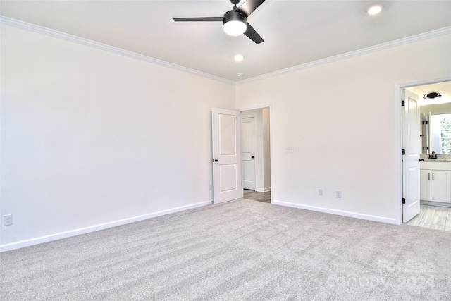 spare room featuring crown molding, light colored carpet, sink, and ceiling fan