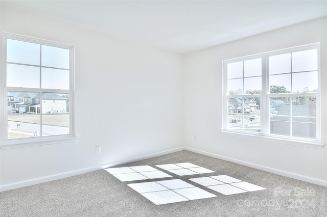 unfurnished room featuring carpet and plenty of natural light