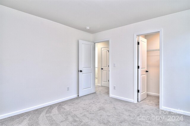 201 Wedge View Way, Statesville, NC 28677 - unfurnished bedroom with a closet, a walk in closet, carpet, and baseboards