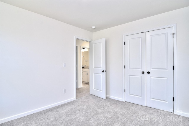 unfurnished bedroom with light colored carpet and a closet