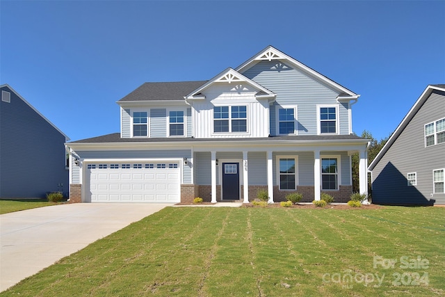 view of front of home with a porch, a front lawn, and a garage