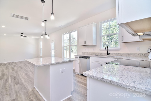 kitchen with a kitchen island, white cabinetry, stainless steel dishwasher, light wood-type flooring, and sink