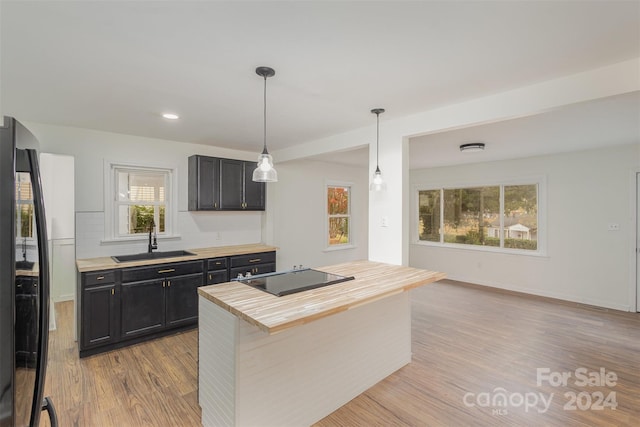 kitchen featuring black appliances, sink, a wealth of natural light, and decorative light fixtures