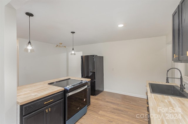 kitchen with black fridge, electric stove, light wood-type flooring, pendant lighting, and sink