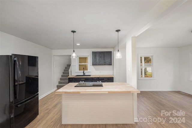 kitchen featuring wooden counters, sink, black appliances, and light hardwood / wood-style flooring