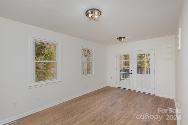 spare room featuring french doors and hardwood / wood-style flooring