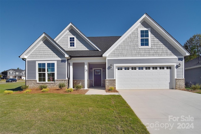 craftsman house with a front lawn and a garage