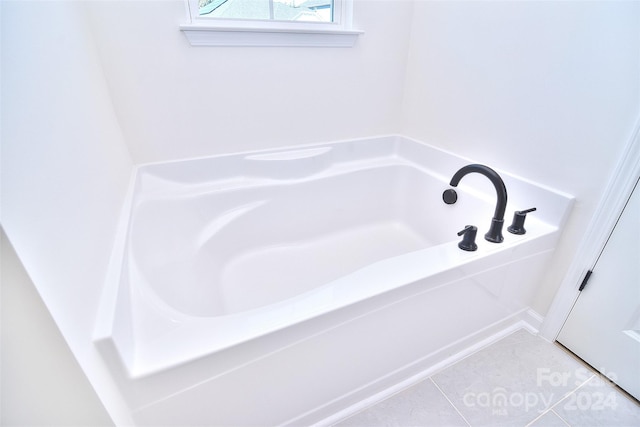 bathroom featuring a washtub and tile patterned flooring