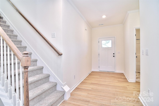 foyer featuring light hardwood / wood-style floors and crown molding